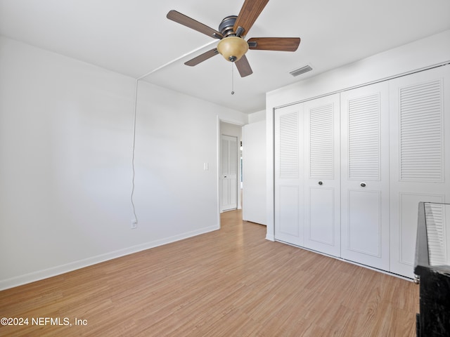 unfurnished bedroom with a closet, light hardwood / wood-style floors, and ceiling fan