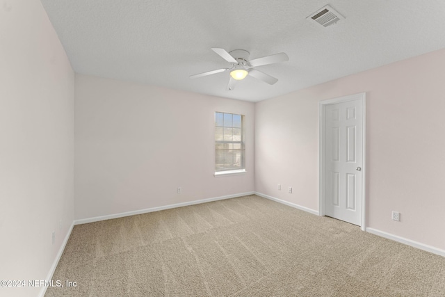 carpeted spare room featuring a textured ceiling and ceiling fan