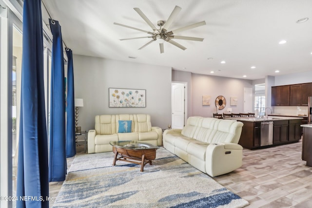 living room with light hardwood / wood-style flooring, sink, and ceiling fan