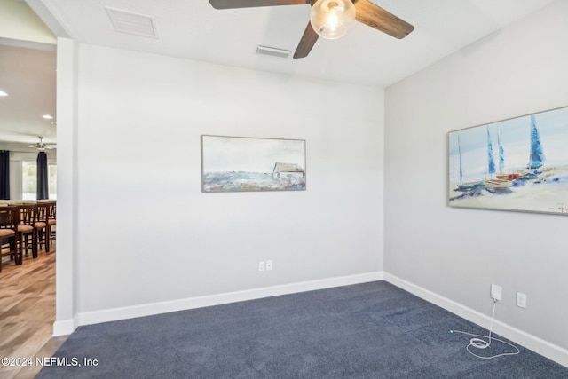 carpeted spare room featuring ceiling fan