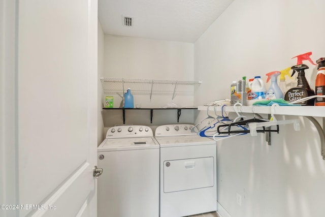 washroom featuring washing machine and dryer and a textured ceiling