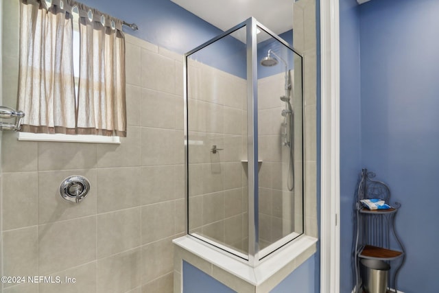 bathroom with a shower with door