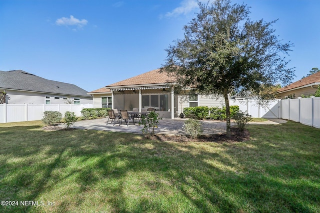 back of house featuring a patio, a lawn, and a sunroom