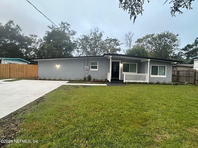 ranch-style home with a front lawn and covered porch