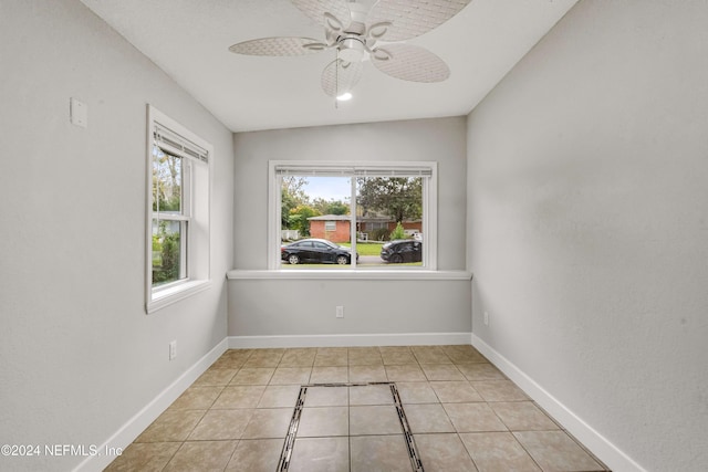 spare room featuring ceiling fan, light tile patterned floors, and vaulted ceiling