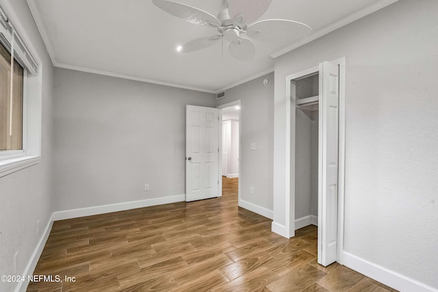 unfurnished bedroom featuring hardwood / wood-style flooring, ceiling fan, ornamental molding, and a closet