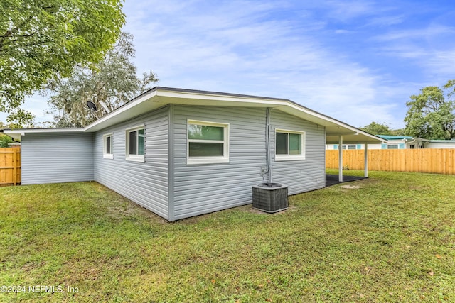 back of property with a lawn and cooling unit