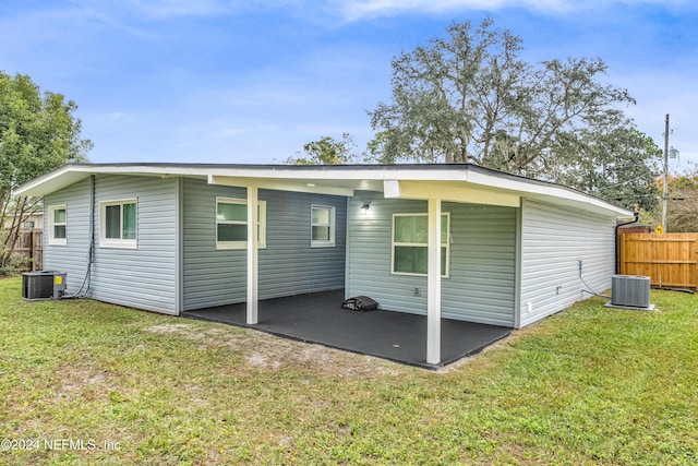 back of house featuring central air condition unit, a yard, and a patio