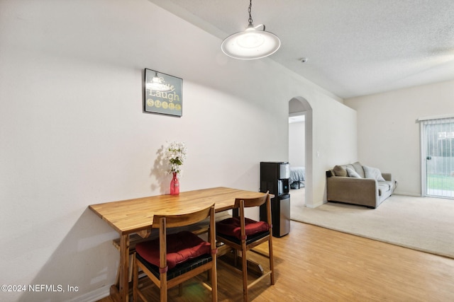 dining area with hardwood / wood-style flooring and a textured ceiling