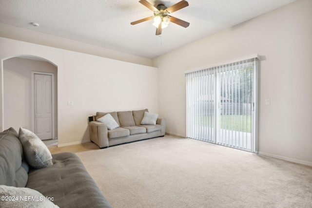 carpeted living room featuring a textured ceiling and ceiling fan