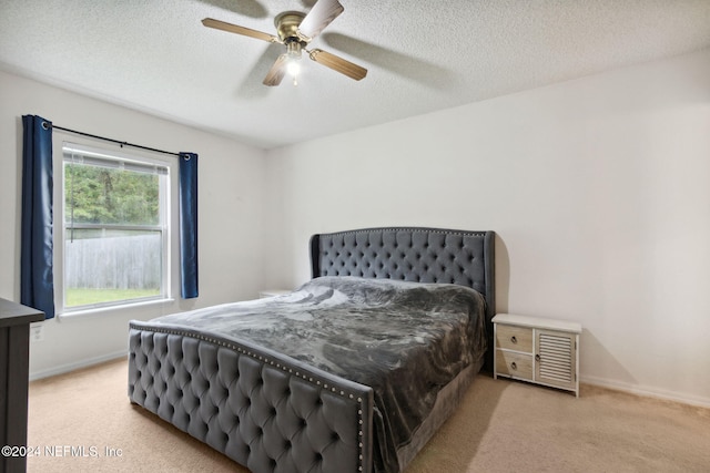 carpeted bedroom with a textured ceiling and ceiling fan