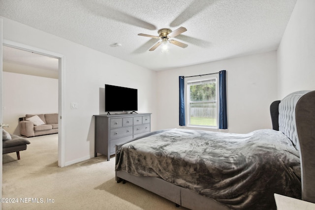 carpeted bedroom featuring a textured ceiling and ceiling fan