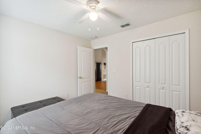 bedroom featuring a closet, ceiling fan, and a textured ceiling