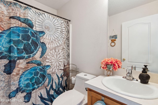 bathroom featuring vanity, a textured ceiling, and toilet