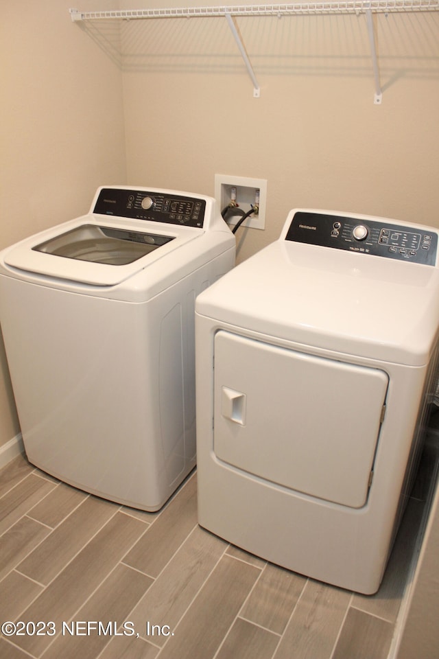 washroom featuring independent washer and dryer and wood-type flooring