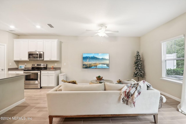 living room featuring light wood-type flooring and ceiling fan