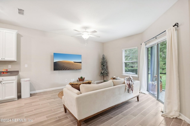 living room featuring light wood-type flooring and ceiling fan