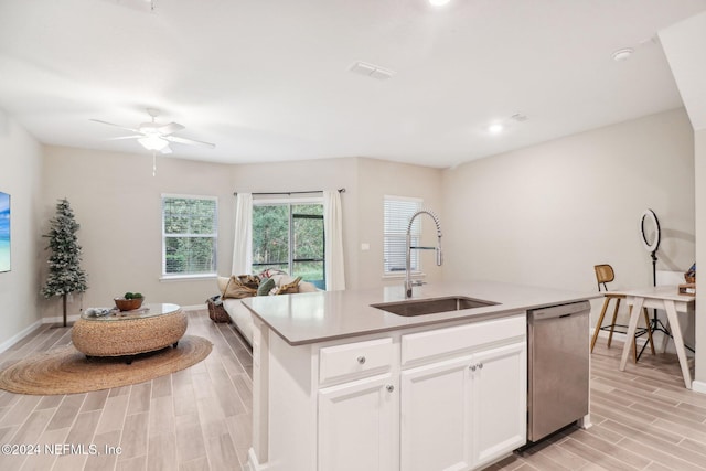 kitchen featuring white cabinetry, sink, stainless steel dishwasher, light hardwood / wood-style floors, and a center island with sink