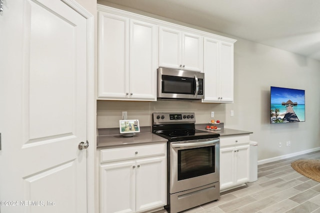 kitchen featuring light wood-type flooring, white cabinetry, and stainless steel appliances