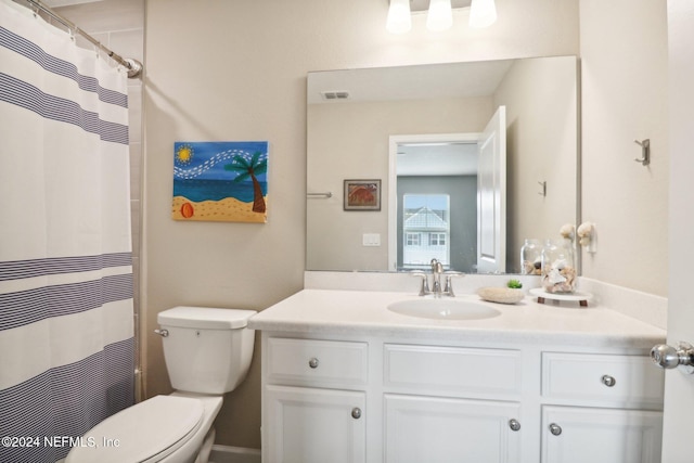 bathroom featuring a shower with shower curtain, vanity, and toilet