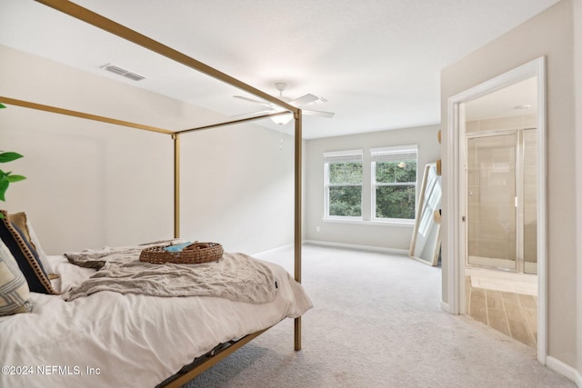 bedroom with connected bathroom, ceiling fan, and light colored carpet