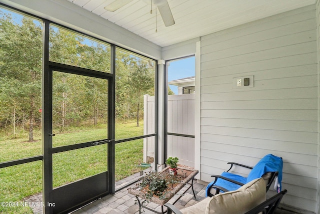 unfurnished sunroom featuring ceiling fan