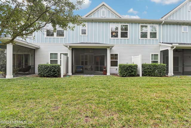 back of property featuring a sunroom and a lawn