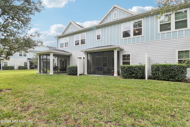 rear view of property featuring a sunroom and a yard