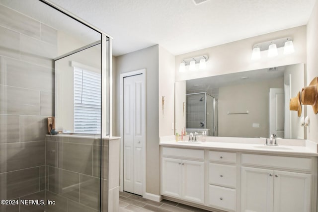 bathroom with a textured ceiling, vanity, wood-type flooring, and a shower with shower door