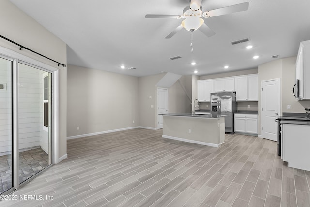 kitchen with appliances with stainless steel finishes, dark countertops, visible vents, and a sink