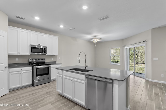 kitchen with visible vents, stainless steel appliances, a sink, and wood finish floors