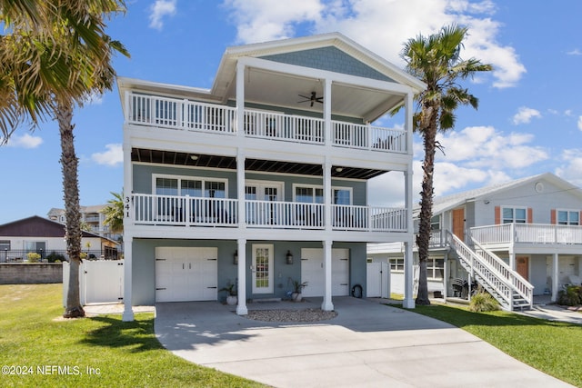 coastal home featuring ceiling fan, a front yard, and a garage