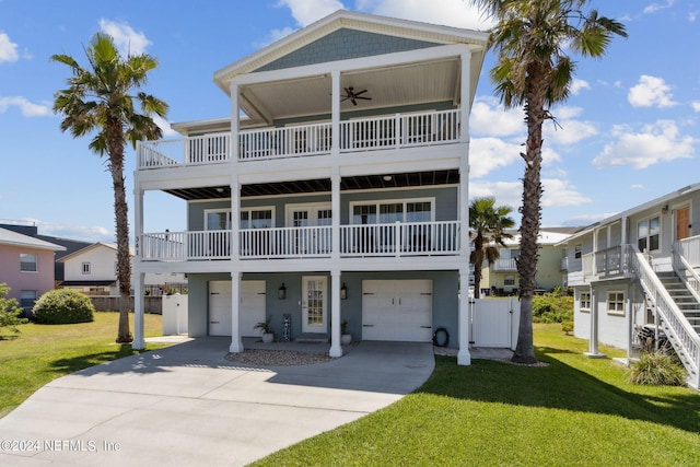 beach home featuring a front yard, a garage, and ceiling fan