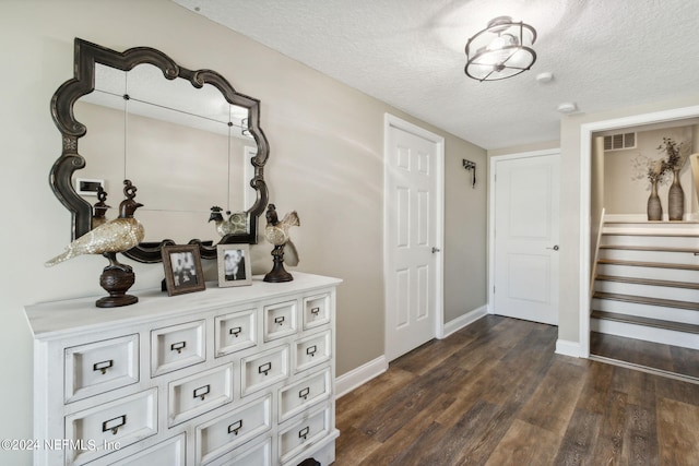 hall featuring a textured ceiling and dark hardwood / wood-style flooring