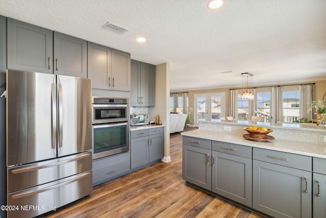 kitchen with appliances with stainless steel finishes, plenty of natural light, and gray cabinets