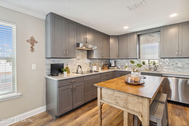 kitchen with tasteful backsplash, stainless steel dishwasher, black electric cooktop, light hardwood / wood-style flooring, and gray cabinets