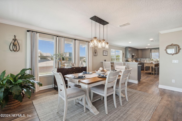 dining space with ornamental molding, a textured ceiling, and dark wood-type flooring