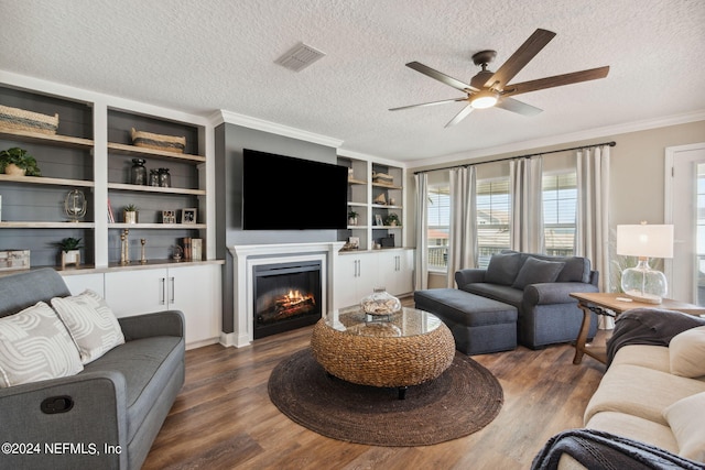 living room featuring dark wood-type flooring, crown molding, a textured ceiling, and ceiling fan