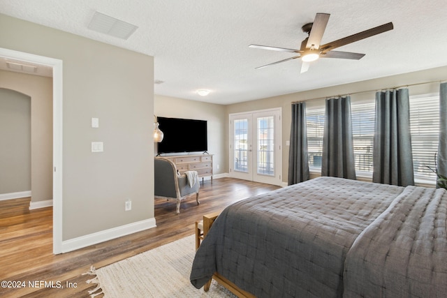 bedroom featuring french doors, access to exterior, hardwood / wood-style floors, a textured ceiling, and ceiling fan