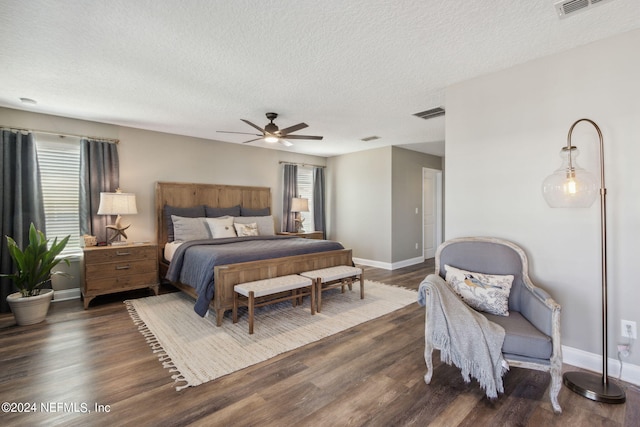 bedroom featuring ceiling fan, a textured ceiling, and dark hardwood / wood-style floors