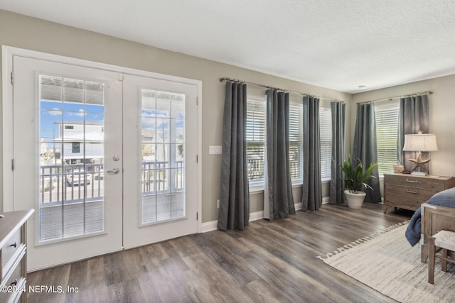 bedroom featuring french doors, a textured ceiling, dark hardwood / wood-style flooring, and access to exterior