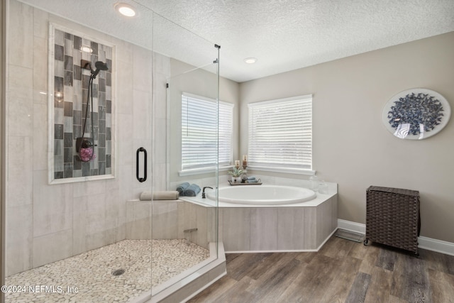 bathroom with hardwood / wood-style floors, plus walk in shower, and a textured ceiling