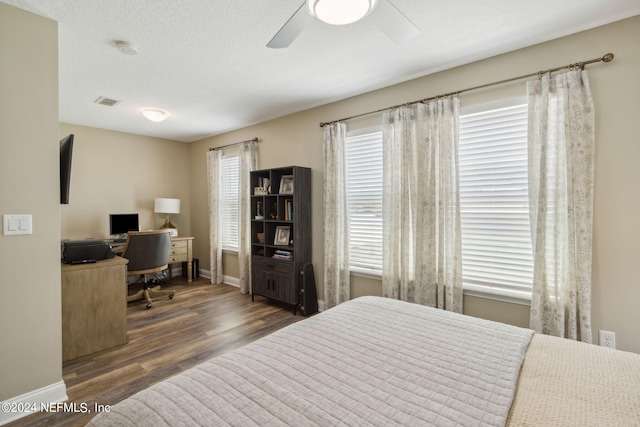 bedroom featuring a textured ceiling, dark hardwood / wood-style floors, and ceiling fan