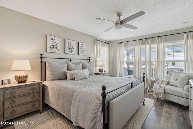 bedroom with ceiling fan, a textured ceiling, multiple windows, and hardwood / wood-style floors