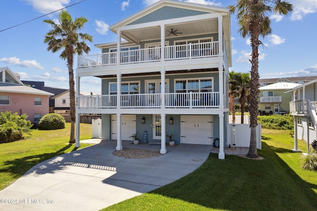 beach home featuring ceiling fan, a front yard, a balcony, and a garage