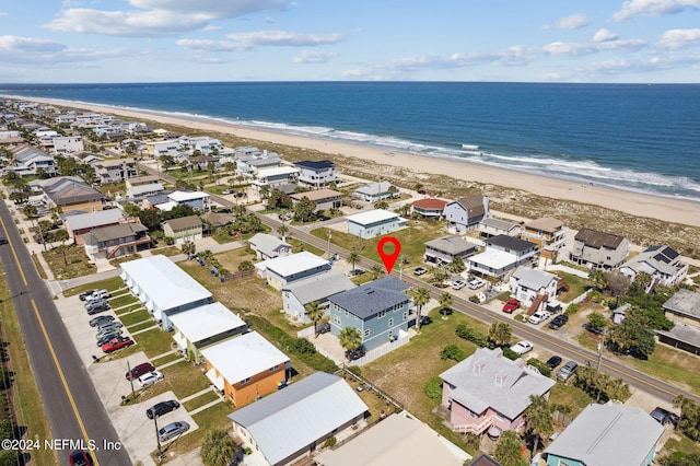 birds eye view of property with a water view and a beach view