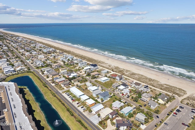 drone / aerial view with a water view and a beach view