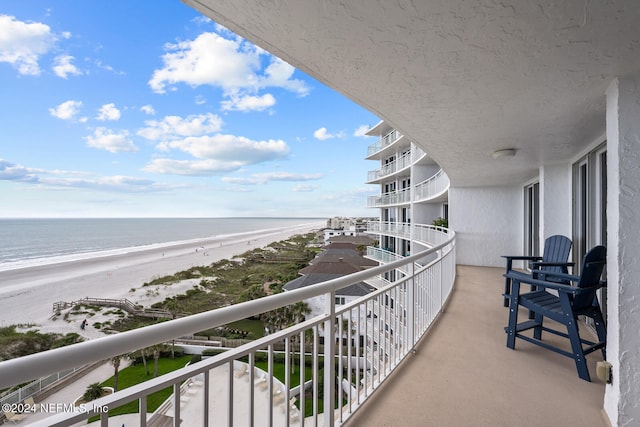 balcony featuring a water view and a view of the beach