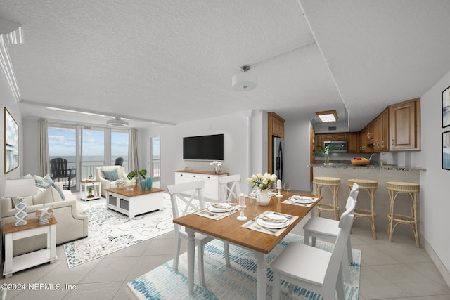 dining room with a textured ceiling and light tile patterned flooring