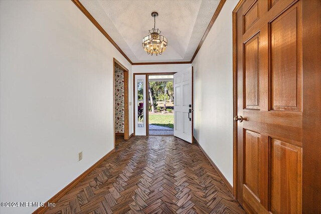 foyer entrance with crown molding, dark parquet floors, a textured ceiling, and a notable chandelier